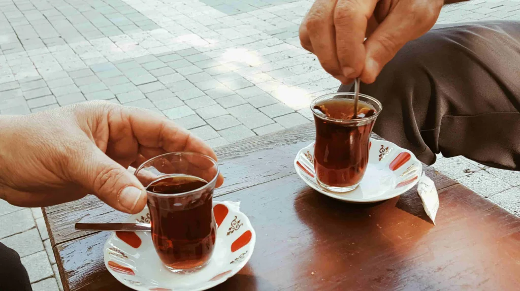 2 people drinking tea in the street