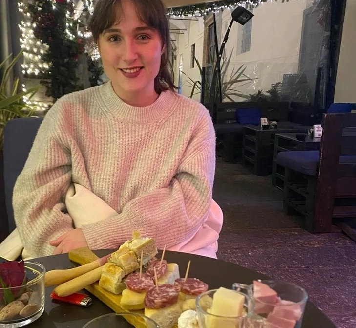 girl sitting in a bar with food in front of her