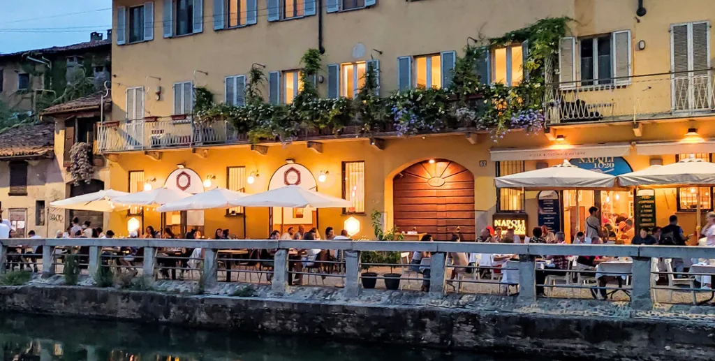 view of restaurants next to a canal in the evening